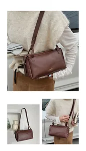 Dettaglio borsa a cuscino marrone vintage con logo dorato e tracolla regolabile