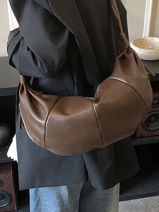 Brown leather crescent croissant shoulder bag with pleated texture and wide strap for women