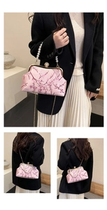Detail of pink embroidered silk evening bag with pearl handle and golden chain