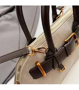 Detailopname van de gouden metalen en suède textuur op de schelpvormige tas