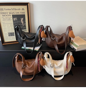 Collection of crescent hobo bags in four colors with plush heart charms on display