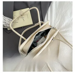 Detail view of the interior capacity of this cream PU leather baguette shoulder bag