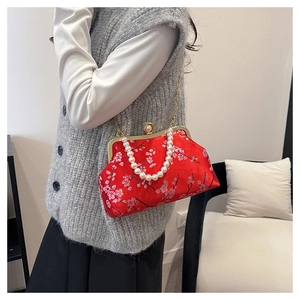 Detail of red satin handbag with plum blossom embroidery and pearl handle strap