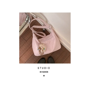 Detailed view of pink dumpling bag with cute bear charm and adjustable shoulder strap
