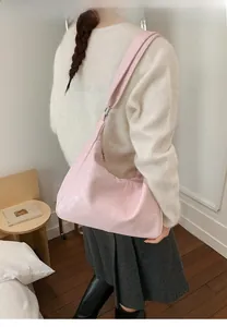 Rear view of a pink leather dumpling bag styled as a chic shoulder and underarm bag