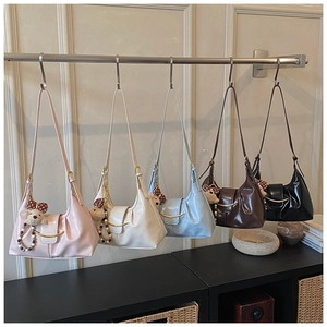Row of colorful crescent hobo bags with metallic gold buckles and cute bear charms