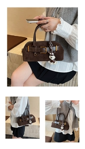 Details einer dunkelbraunen Wildlederhandtasche mit Vintage-Schnalle und Hundeanhänger
