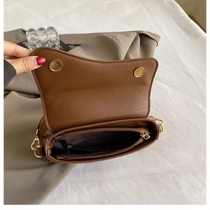Dettaglio interno di una borsa a sella marrone con tasca zip e chiusura magnetica