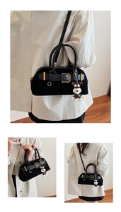 Details der schwarzen Vintage Boston-Handtasche mit Goldschnalle und Schnauzer-Anhänger