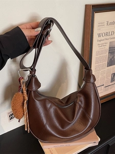 Retro dark brown crescent shoulder bag in PU leather with plush charm and strap detail