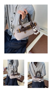 Detailansicht der grauen Wildledertasche mit braunen Lederriemen und süßem Hundeanhänger