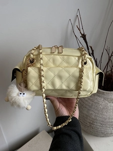 Sac bandoulière matelassé jaune pâle avec chaîne dorée et breloque peluche blanche