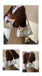 Detailed view of light blue shoulder bag with golden metal clasp and plush bear charm
