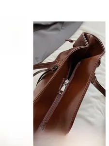 Detail of smooth silver zipper on a brown oily wax leather tote bag with spacious interior