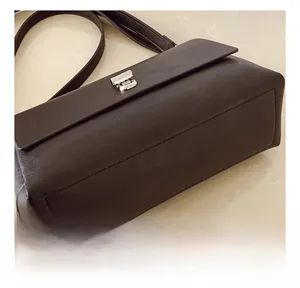 Detail of precise stitching and durable seams on dark brown faux leather crossbody bag