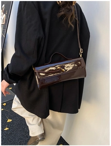 Vue détaillée du sac en cuir verni bordeaux avec boucle en métal doré en forme de nœud