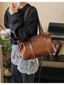 Macro shot of brown faux suede hobo bag with vintage metal zipper and buckle details
