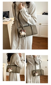 Detail of olive green oil wax leather baguette bag with a cute plush bear charm