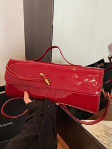 Sac baguette en cuir verni rouge brillant avec boucle nœud dorée et bandoulière