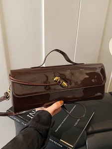 Sac baguette en cuir verni marron foncé brillant avec fermoir doré torsadé élégant