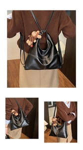 Black leather tote bag featuring white contrast stitching and a plush bear charm detail