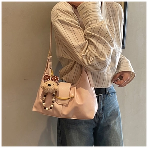 Detailed view of light pink faux leather shoulder bag with plush bear and bead charms
