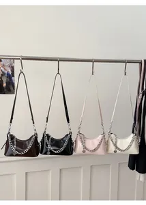 Close-up of stylish chain handbags in four colors with heart pendants and silver chains