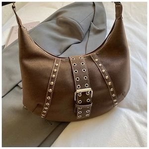 Dettaglio macro della borsa hobo in pelle scamosciata marrone con borchie e fibbia vintage