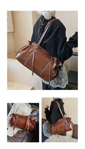 Detail of vintage brown leather tote bag with large capacity and stylish fringe zippers