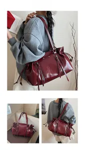 Deep red patent leather tote bag detail with vertical zippers and side drawstring design