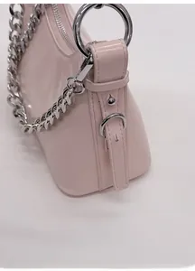 Detail of pink leather handbag showing shiny silver chain and adjustable buckle strap