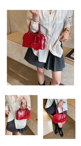 Detail of red vintage top handle handbag with heart pendant and model lifestyle shot