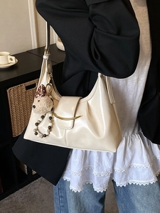 Chic cream white underarm bag with gold buckle and cute puppy charm on a shoulder strap