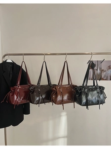 Detail of Boston bags in burgundy, coffee, brown, and black with fringe tassel zip charms