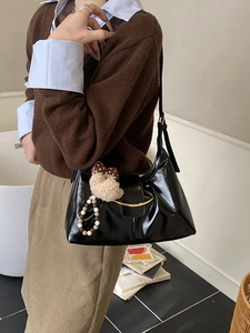 Retro black glossy leather shoulder bag with gold hardware and plush bear pendant detail