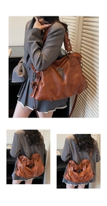 Detail of brown vintage tote bag with metal cross and chain on textured leather