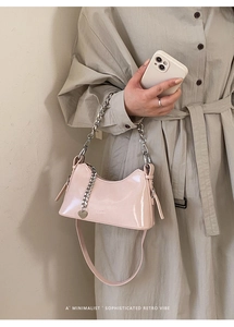 Detail of pink oil wax leather baguette bag with silver chain and heart charm