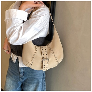 Dettaglio borsa hobo beige con rivetti metallici, occhielli e fibbia in ecopelle opaca