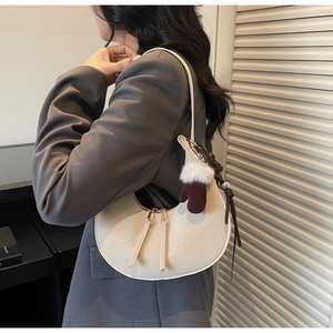 Borsa a luna chic in pelle opaca color avena con ciondolo a forma di guanto in peluche