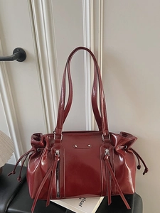 Retro deep red glossy faux leather tote bag with stylish vertical zippers and tassels