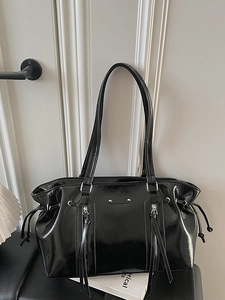 Glossy black faux leather shoulder bag with vertical zippers and vintage biker aesthetic