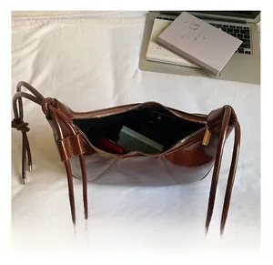 Macro view of dark brown polished leather crescent bag showing internal storage capacity