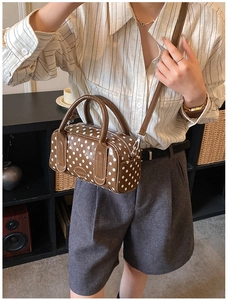 Detailed view of a vintage polka dot Boston bag in brown PU leather with top handle