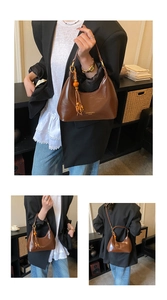 Détail du sac sous le bras en cuir verni marron avec perles en bois et pompon chic