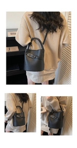 Detail view of black lychee leather bucket bag with silver hardware and cross-body strap