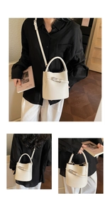 Detailed view of white lychee grain leather bucket bag with silver metal buckles