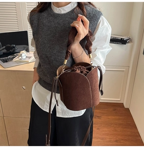 Détail du sac seau en daim marron foncé avec design pétales et poignée froncée