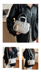 Détail d'un sac bandoulière en PU tissé blanc avec matelassage et breloque en perles ethniques