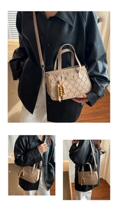 Vue détaillée du sac à main beige tressé avec breloque en bois et plaque logo en métal