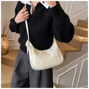 White crescent bag in glossy patent leather with stylish knotted shoulder strap detail